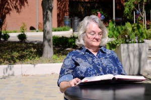 Older student studying textbook at an outdoor patio